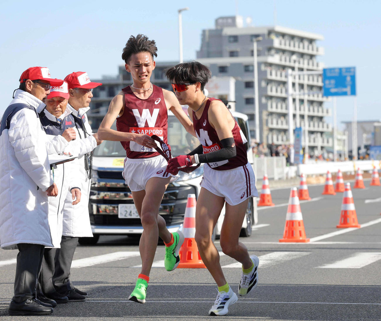 平塚中継所で早大3区山口竣（左）から4区鈴木へタスキをつなぐ（代表撮影）