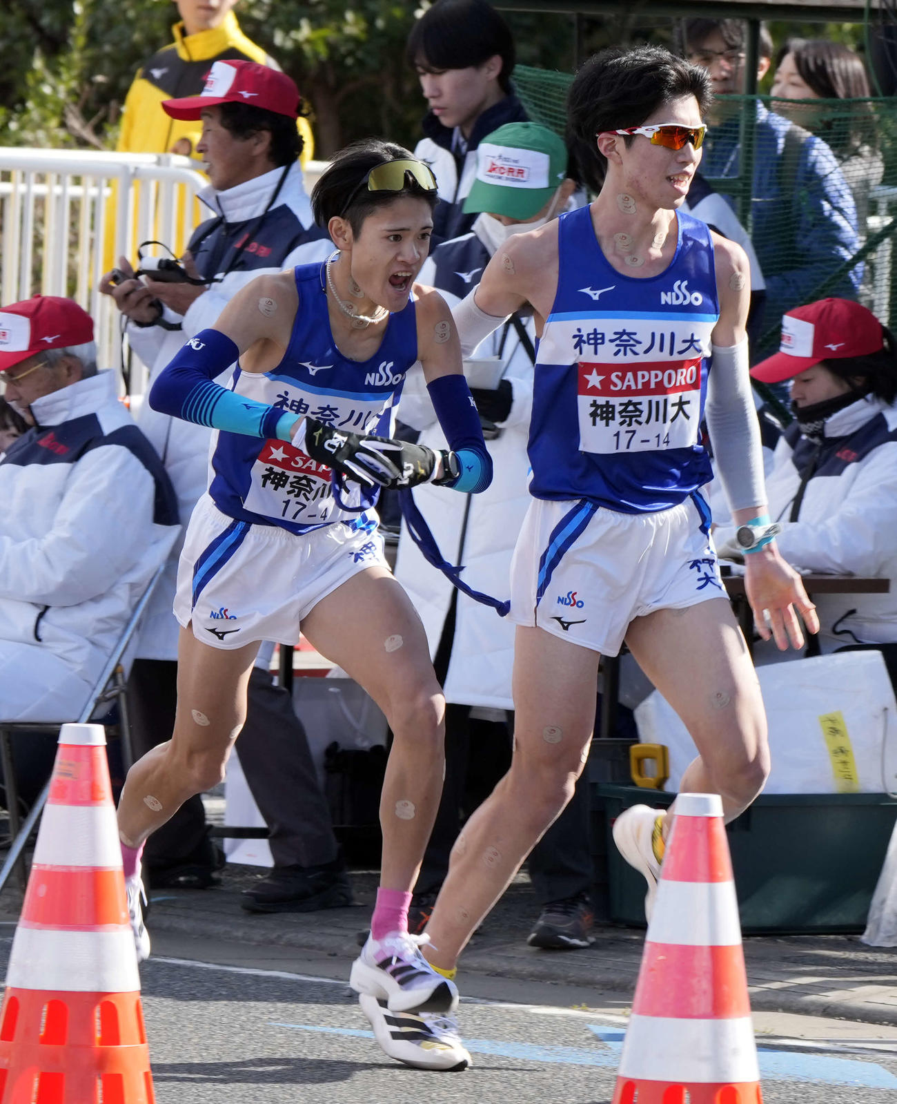 平塚中継所に向かう神奈川大3区新妻（右）は平川にタスキをつなぐ（撮影・小島史椰）