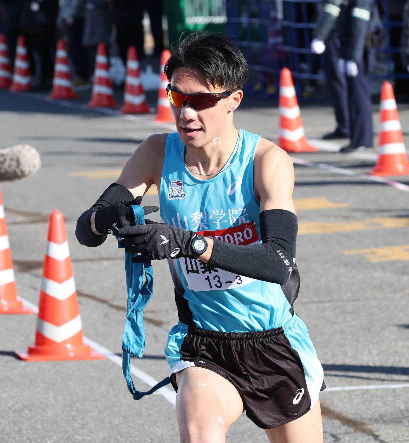 戸塚中継所でタスキを受け駆け出す山梨学院大3区占部（撮影・宮地輝）