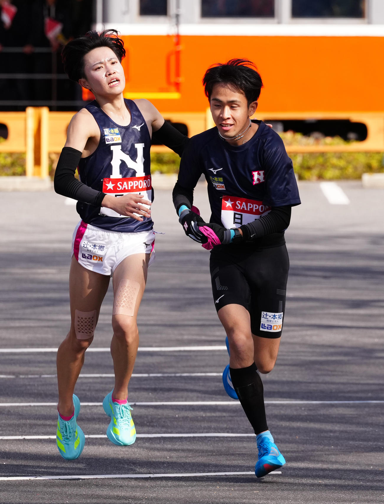 小田原中継所で5区鈴木（右）にたすきを渡す日大4区片桐（撮影・鈴木みどり）