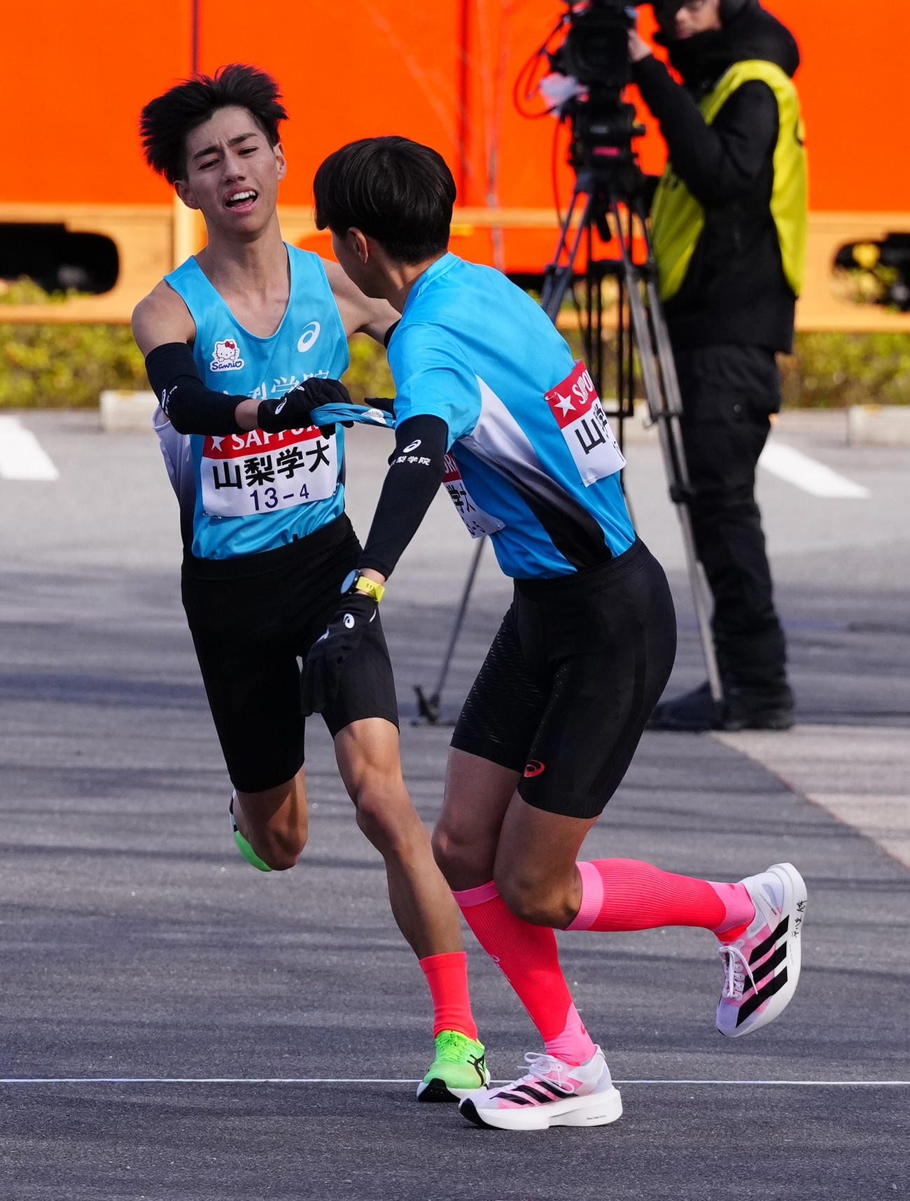 小田原中継所で5区弓削（右）にたすきを渡す山梨学院大4区阿部（撮影・鈴木みどり）