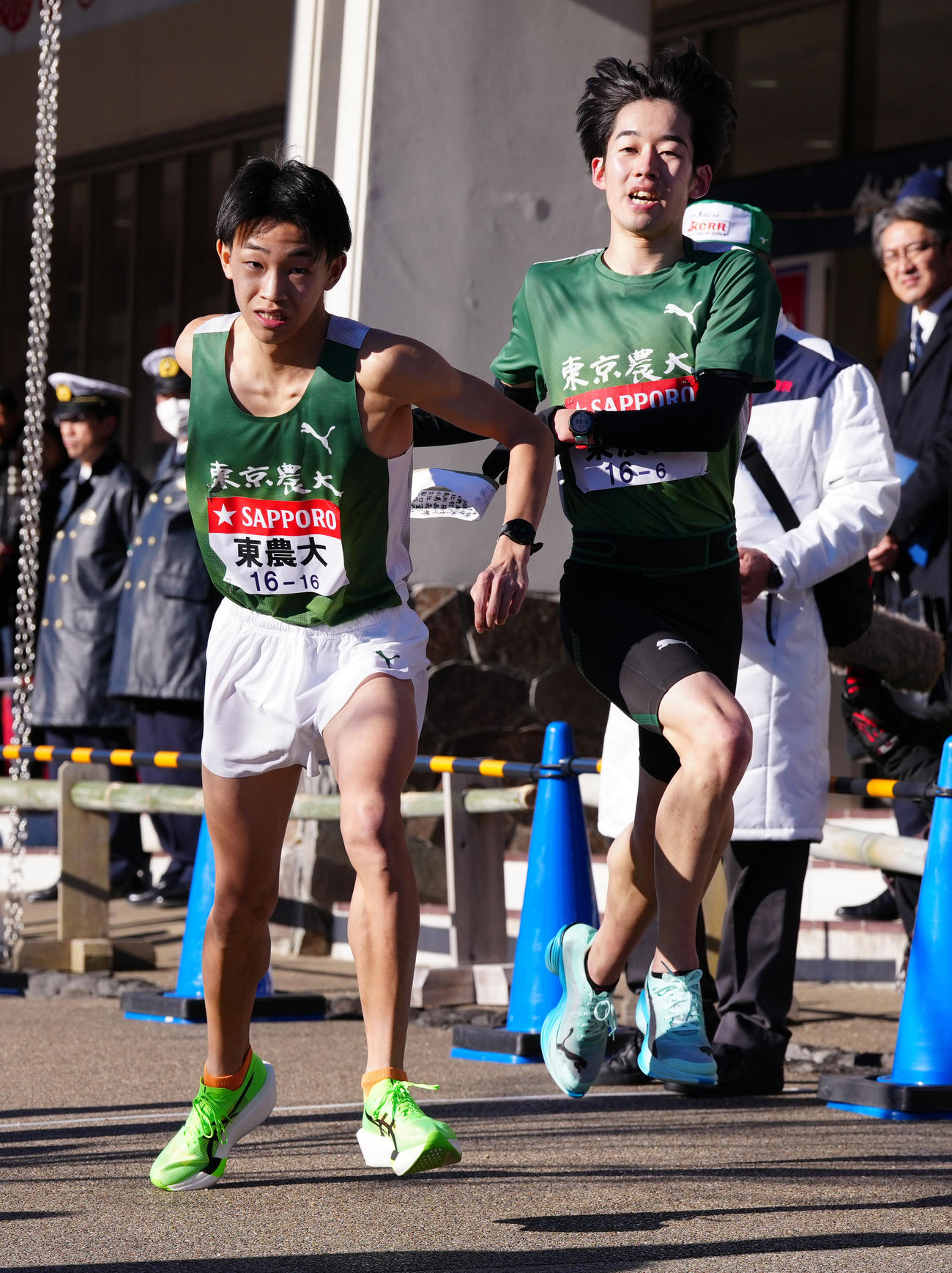 小田原中継所で7区内田（左）にたすきを渡す東農大6区梅原（撮影・鈴木みどり）