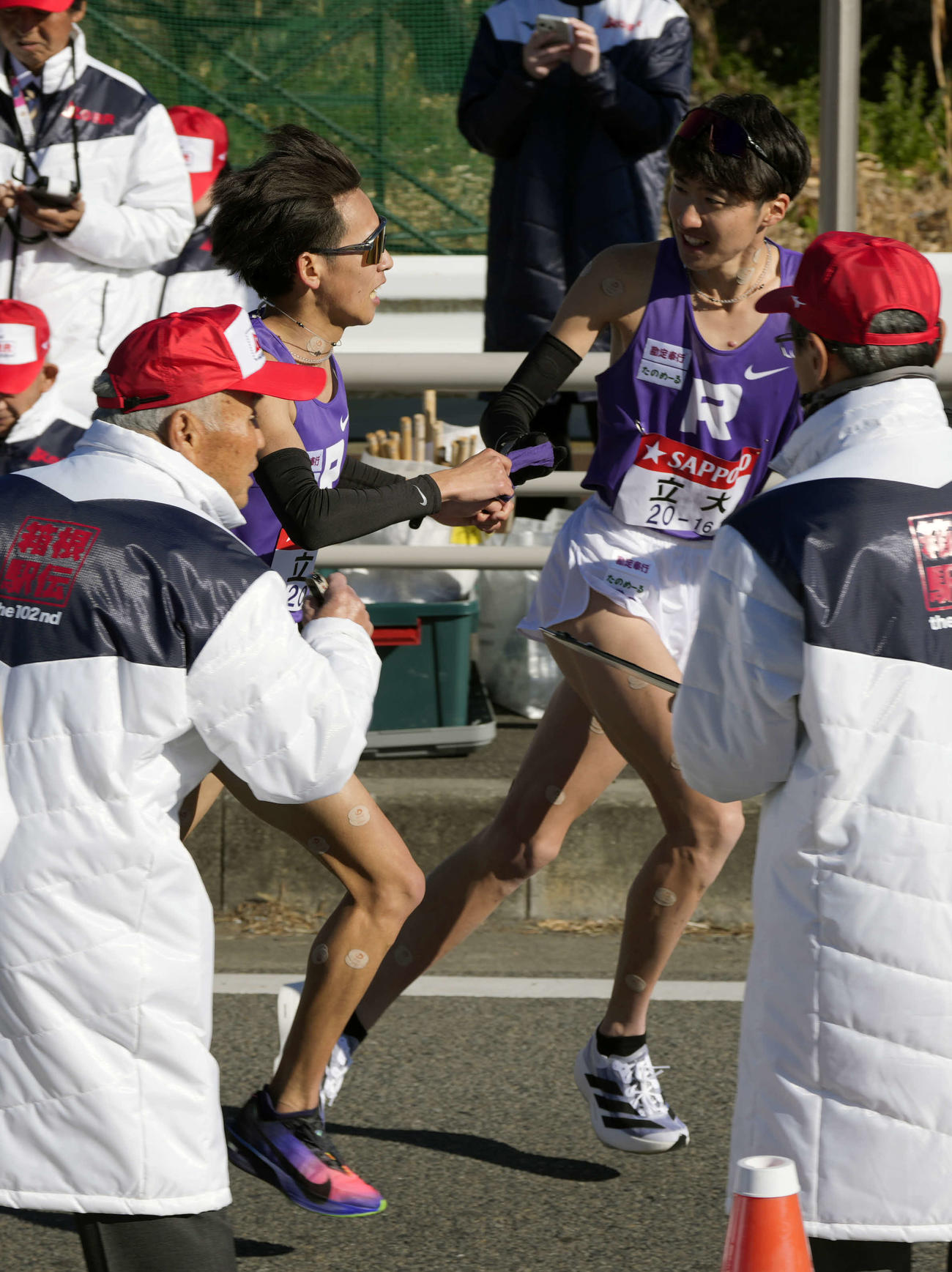 平塚中継所に向かう立大7区小倉（左から2番目）は山下（右から2番目）にタスキをつなぐ（撮影・小島史椰）