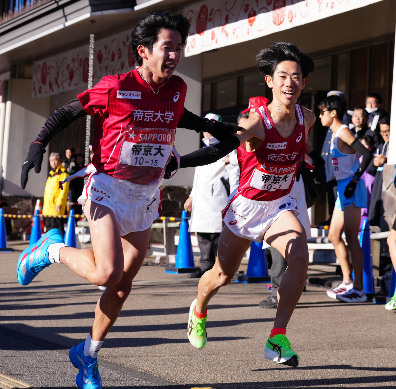 小田原中継所で7区柴戸（右）にたすきを渡す帝京大6区広田（撮影・鈴木みどり）