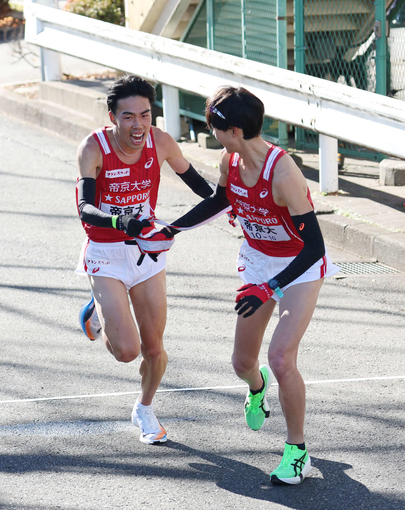 鶴見中継所で10区鎗田大輝（右）にタスキリレーをする帝京大9区尾崎（撮影・増田悦実）