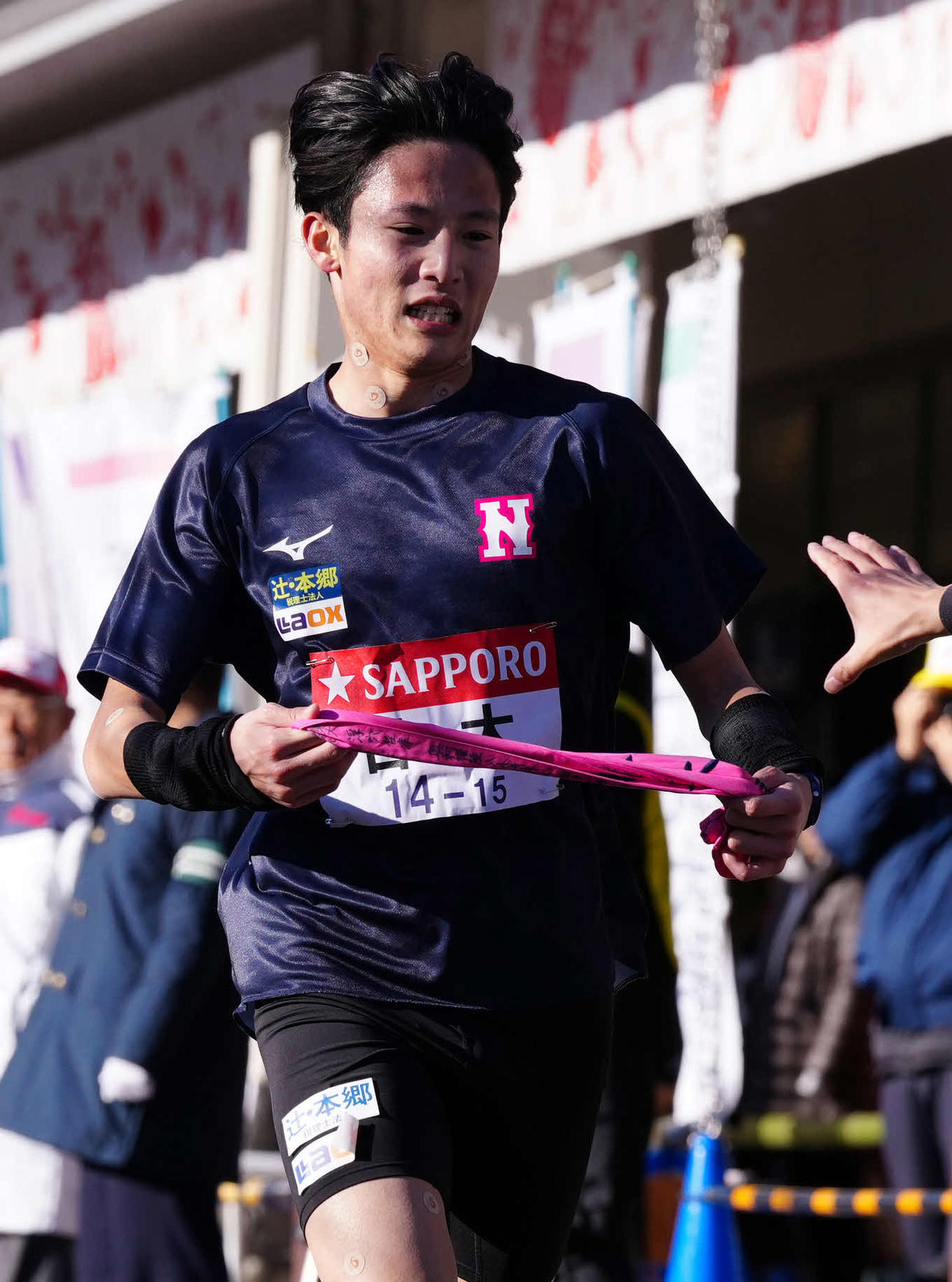 小田原中継所で7区天野（右）にたすきを渡す日大6区山口（撮影・鈴木みどり）