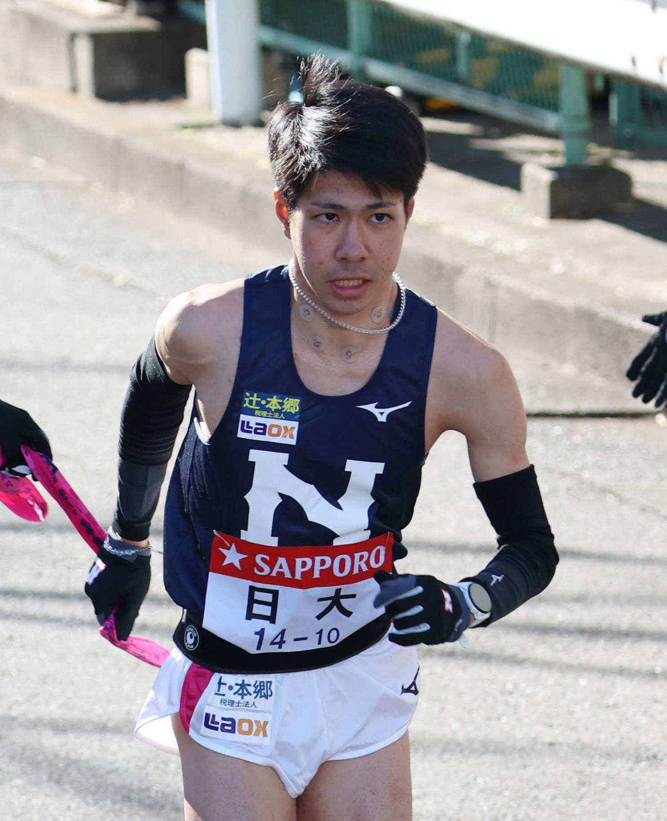 鶴見中継所でタスキを受け取り走り出す日大10区大仲（撮影・増田悦実）