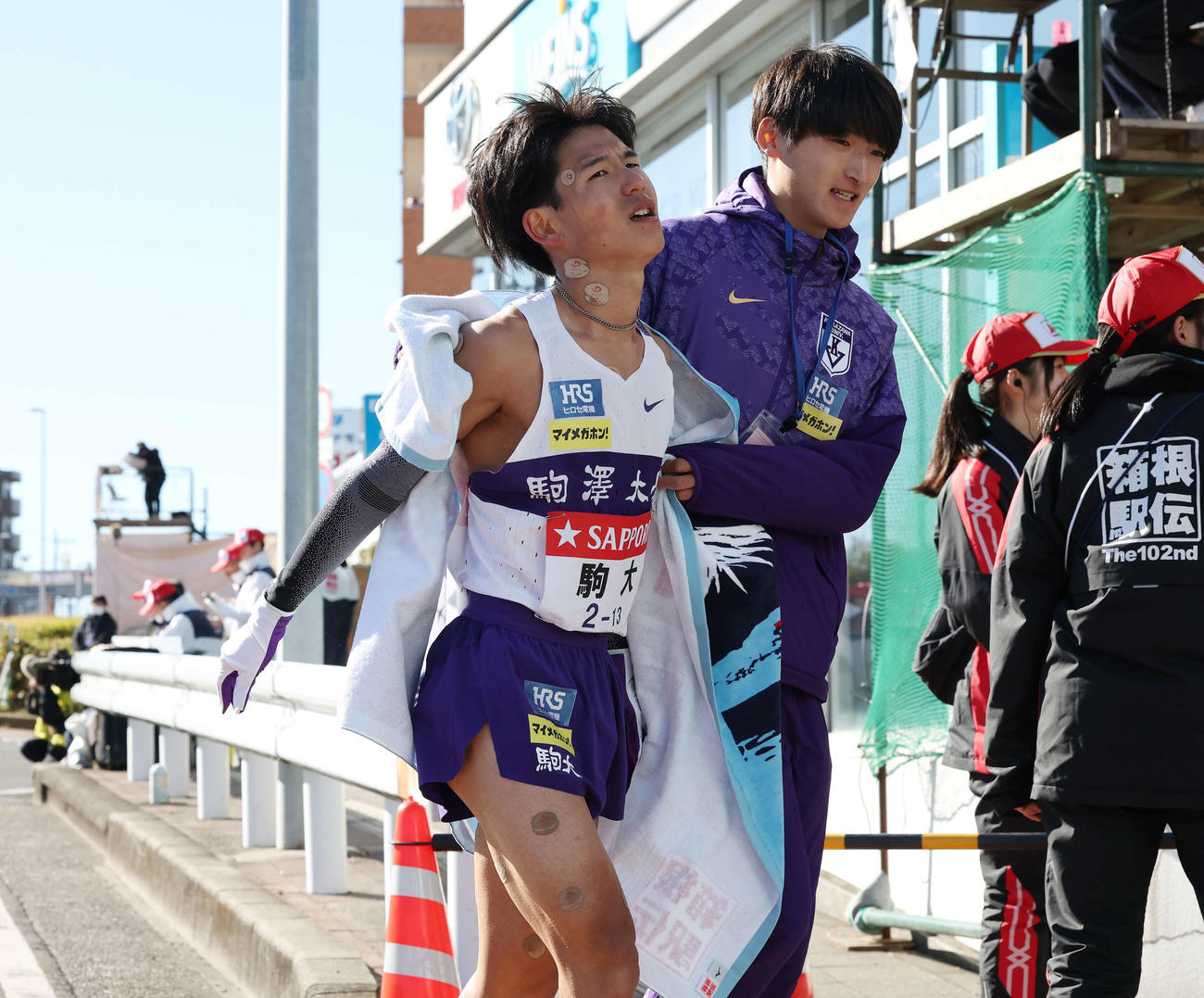 戸塚中継所でタスキをつなぎ仲間に迎えられる駒大8区山川（撮影・宮地輝）