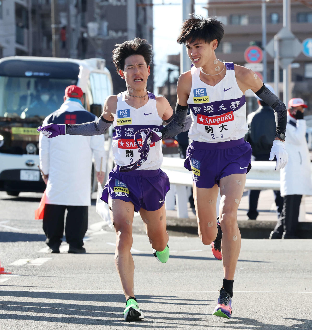 戸塚中継所で駒大8区山川（左）は9区菅谷にタスキをつなぐ（撮影・宮地輝）