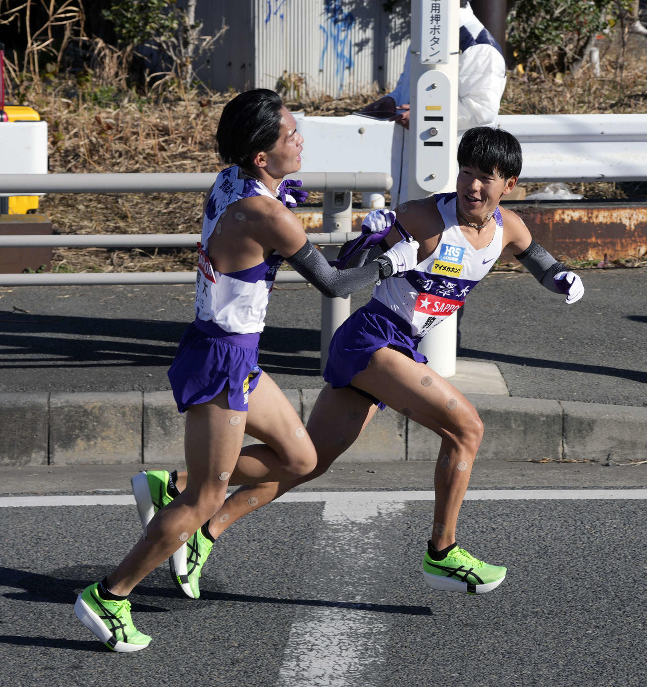 平塚中継所に向かう駒大7区谷中（左）は山川にタスキをつなぐ（撮影・小島史椰）