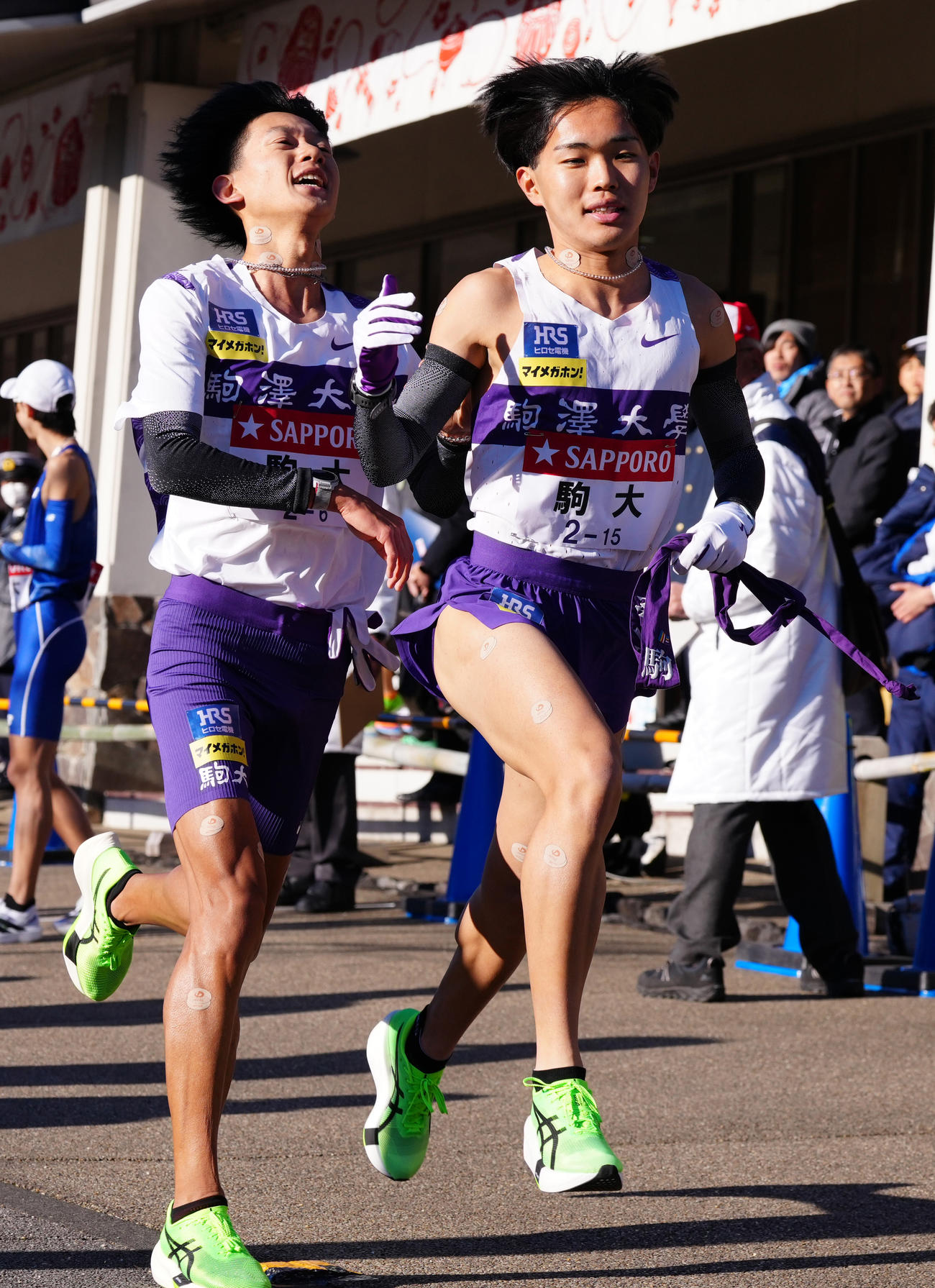 小田原中継所で7区谷中（右）にたすきを渡す駒大6区伊藤（撮影・鈴木みどり）
