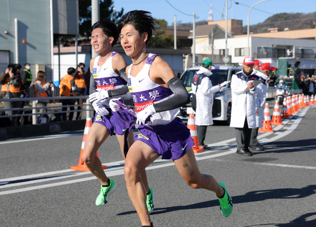7区谷中（左）からたすきを受け取る駒大8区山川（代表撮影）