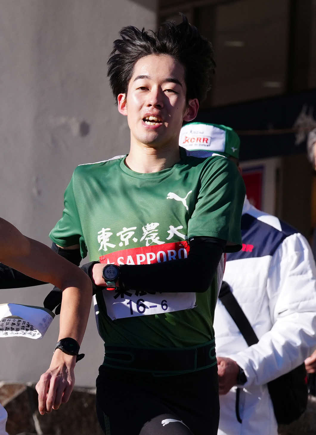 小田原中継所で7区内田にたすきを渡す東農大6区梅原（撮影・鈴木みどり）