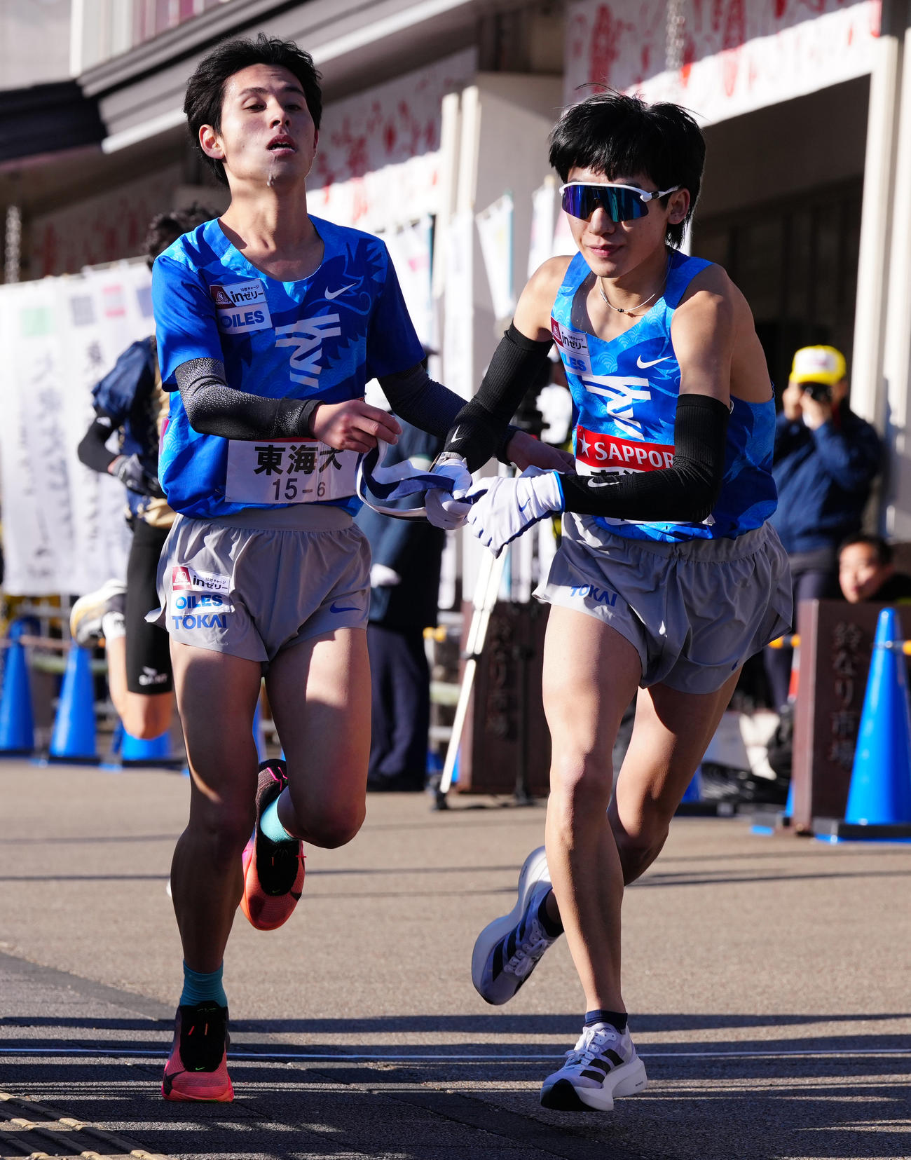 小田原中継所で7区鈴木（右）にたすきを渡す東海大6区水野（撮影・鈴木みどり）