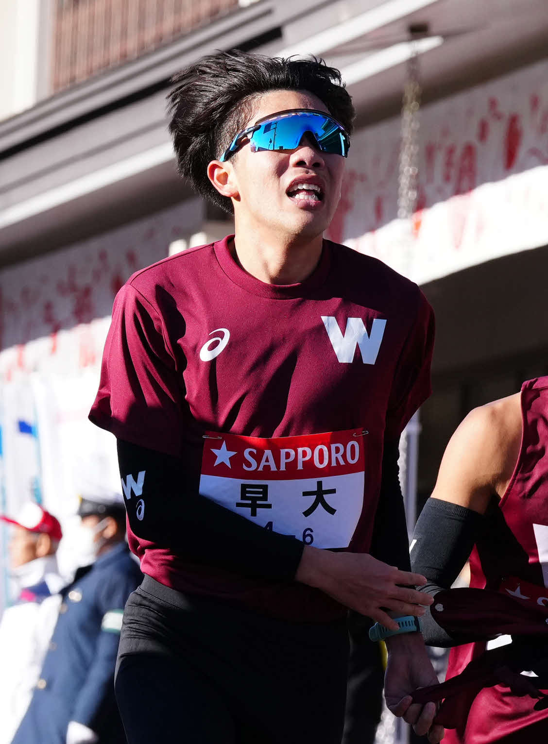 小田原中継所で7区間瀬田にたすきを渡す早大6区山崎（撮影・鈴木みどり）