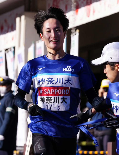 小田原中継所で7区滝本にたすきを渡す神奈川大6区大岩（撮影・鈴木みどり）