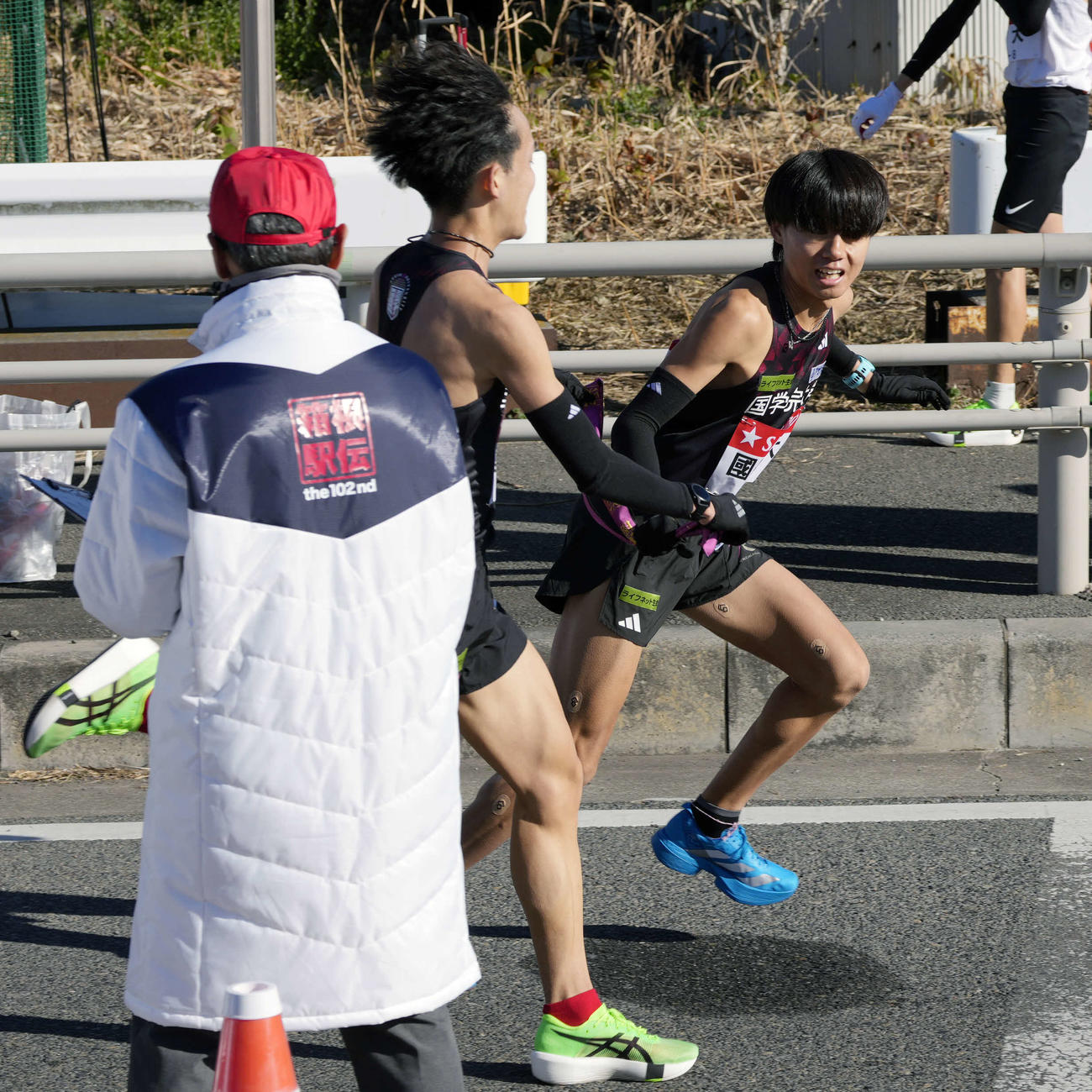 平塚中継所に向かう国学院大7区高山（中央）は飯國（右）にタスキをつなぐ（撮影・小島史椰）