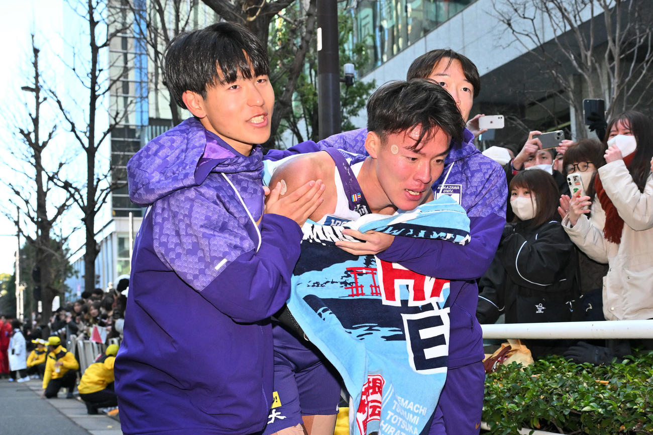 ゴール後、駒大8区山川（左）に抱えられ引き揚げる10区佐藤（中央）（撮影・滝沢徹郎）