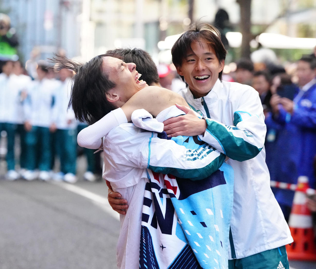 箱根駅伝総合優勝のゴールテープを切った青学大10区折田（中央）と抱き合う黒田。右は塩出（撮影・江口和貴）
