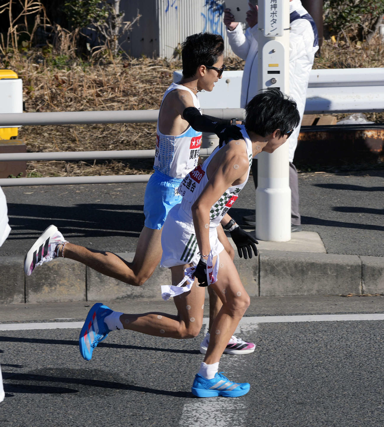 平塚中継所に向かう関東学生連合7区東大・秋吉（左）は横尾にタスキをつなぐ（撮影・小島史椰）