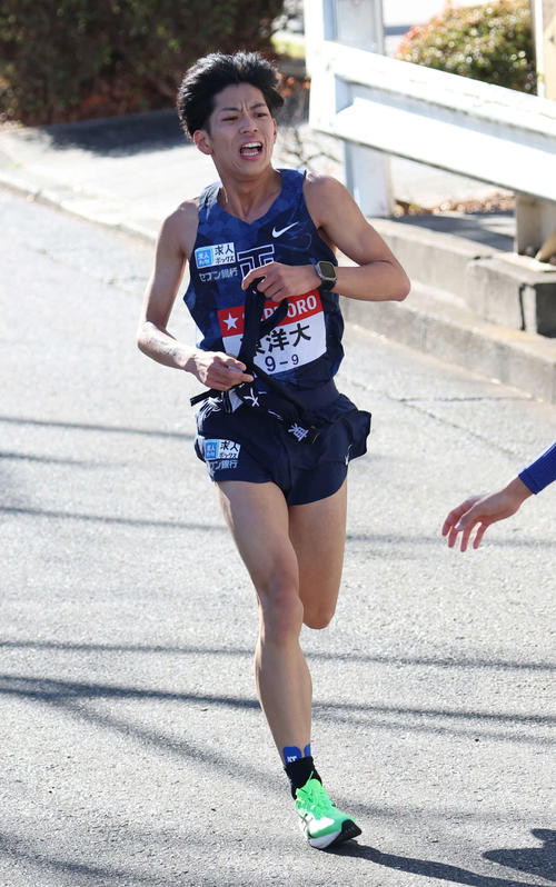 鶴見中継所で10区薄根（右）にタスキリレーをする東洋大9区久保田（撮影・増田悦実）