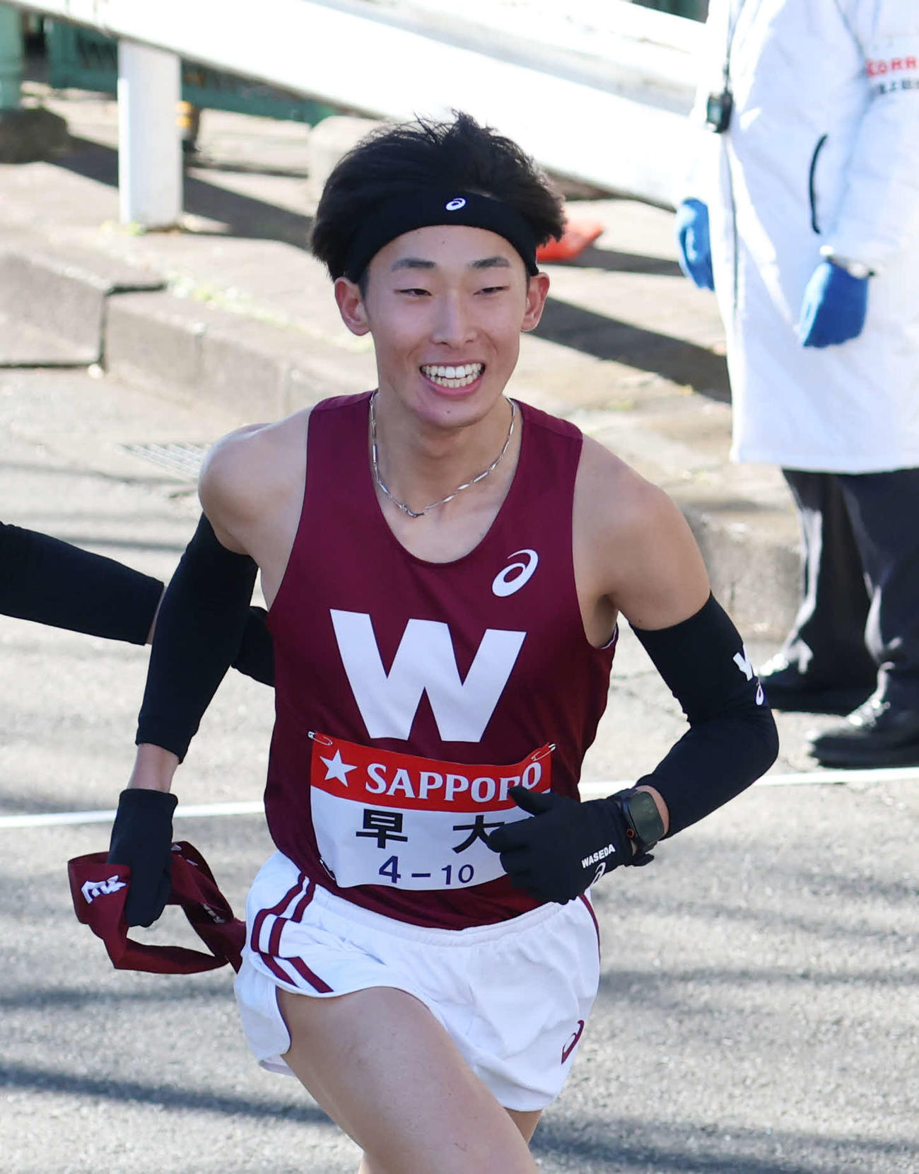 鶴見中継所でタスキを受け取り走り出す明大10区瀬間（撮影・増田悦実）