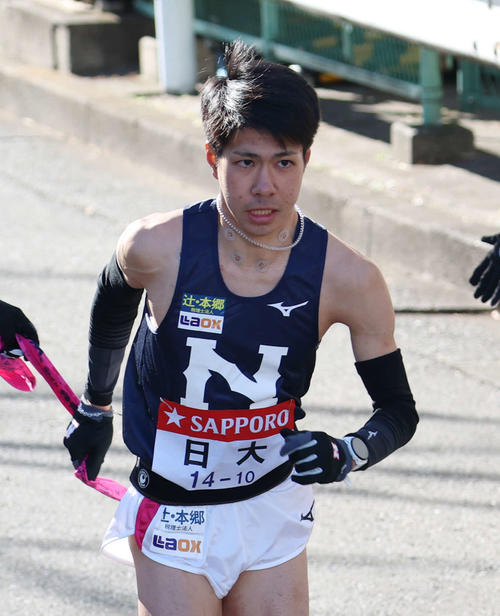 鶴見中継所でタスキを受け取り走り出す日大10区大仲（撮影・増田悦実）