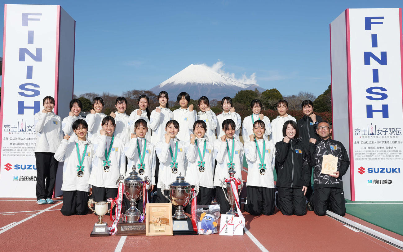 富士山女子駅伝を制し笑顔でガッツポーズする城西大の選手と赤羽周平監督、有紀子コーチ（前列右の2人）（2025年12月30日）