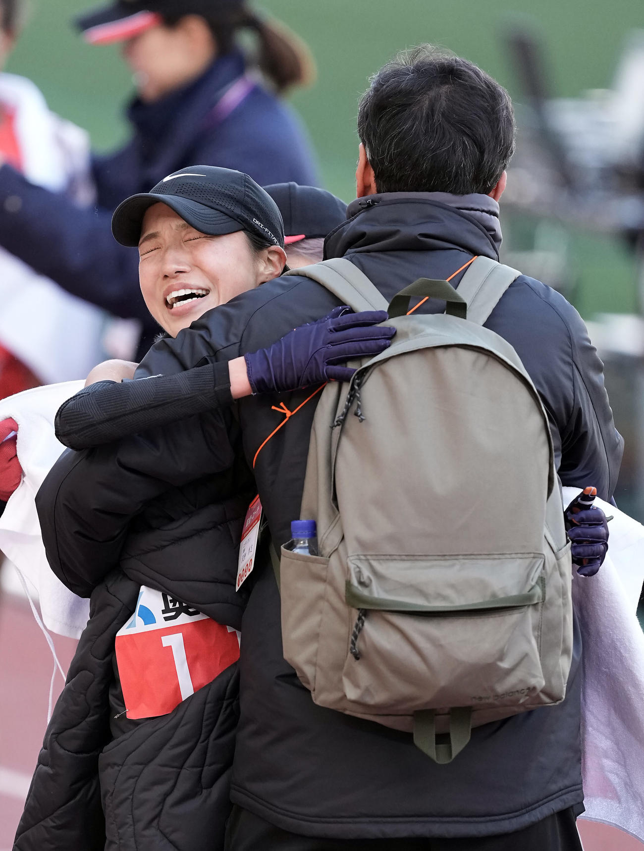 日本人トップの4位でゴールし、沢柳監督（右）と抱き合う矢田（撮影・前田充）