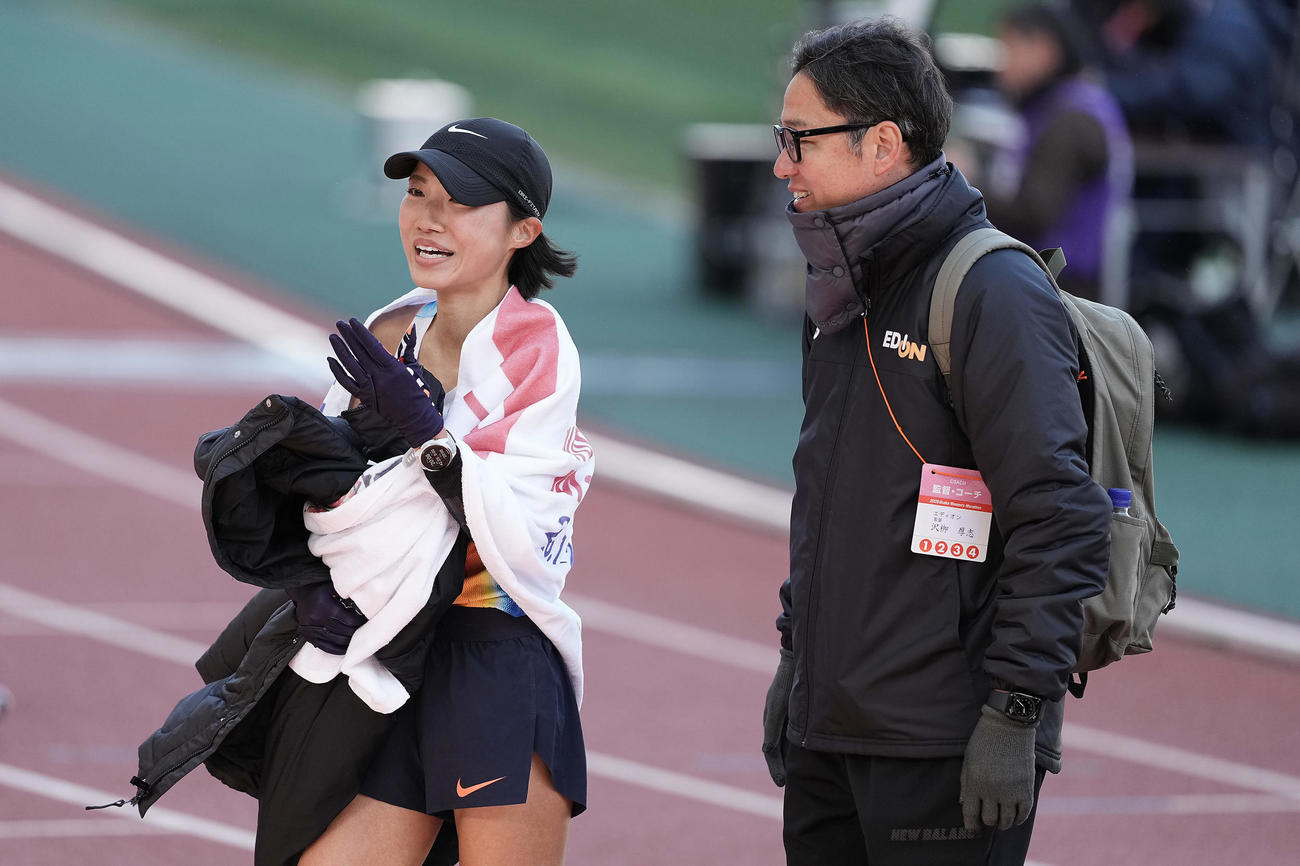 日本人トップの4位でゴールし、笑顔を見せる矢田。右は沢柳監督（撮影・前田充）