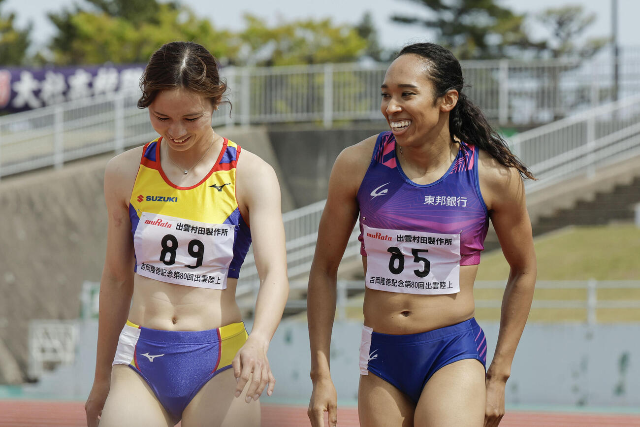 女子100 メートル で優勝し、笑顔を見せる井戸アビゲイル風果（右）＝島根県立浜山公園陸上競技場