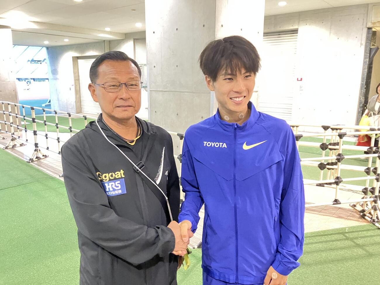 握手する駒大の大八木弘明総監督（左）とトヨタ自動車の鈴木芽吹