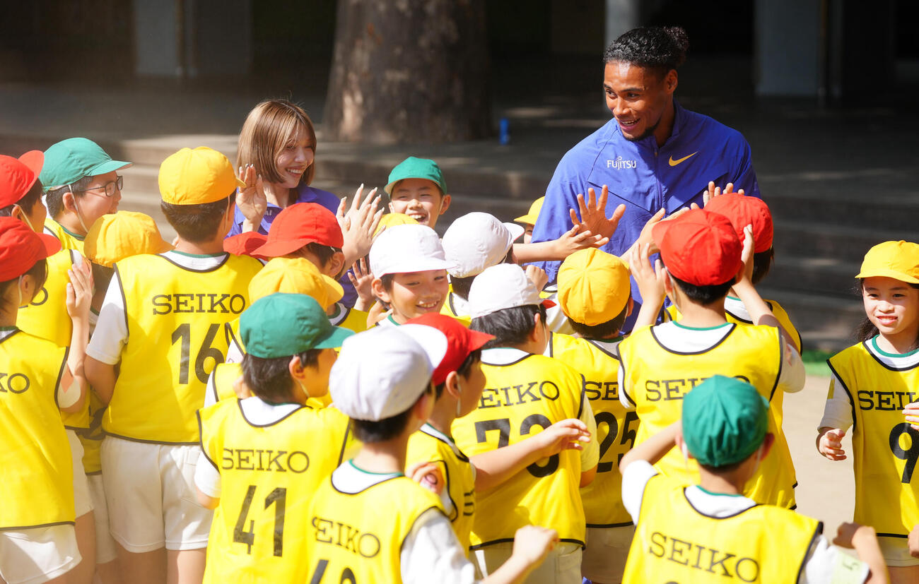 「RIKUJO JAPAN　小学校訪問陸上交流会」で、子供たちとハイタッチする中島佑気ジョセフ（右）と中島ひとみ（撮影・鈴木みどり）