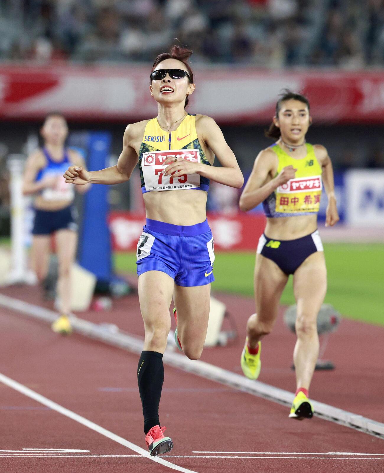 女子5000メートル　ゴールする山本有真。右は田中希実＝パロマ瑞穂スタジアム（共同）