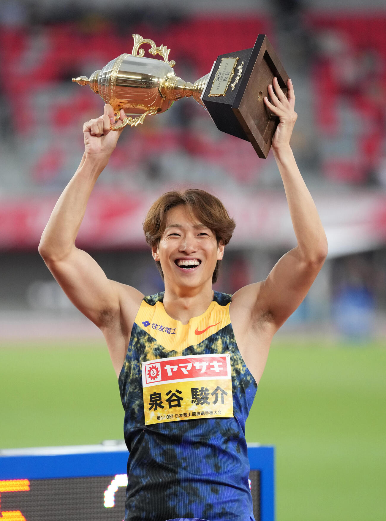 第110回日本陸上競技選手権大会　男子110メートル障害決勝、優勝しトロフィーを掲げる泉谷駿介（撮影・森本幸一）