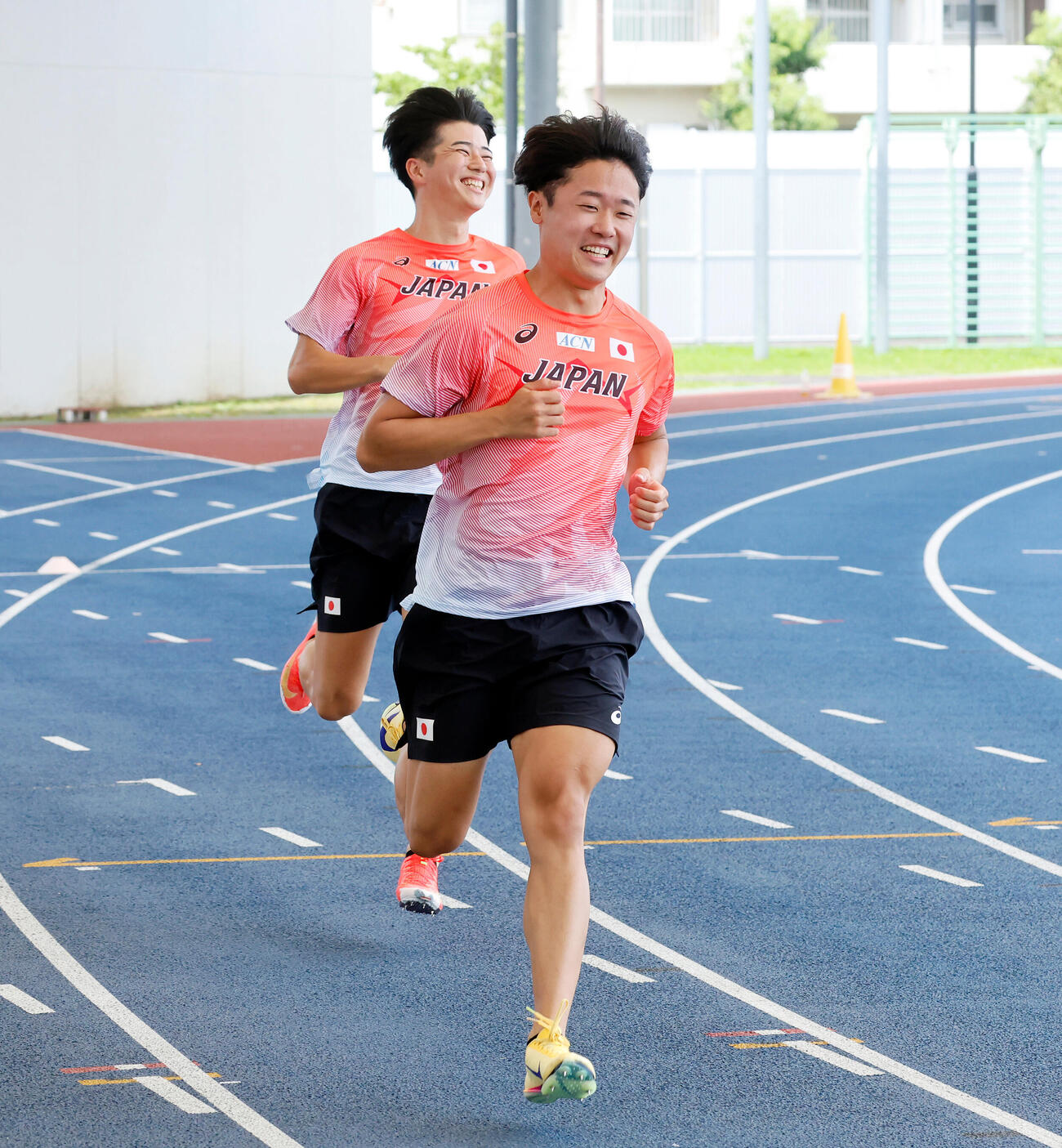 バトンパスの練習でタイミングが合わず、笑みがこぼれる小室歩久斗と多田修平（奥）（撮影・山本朝陽）