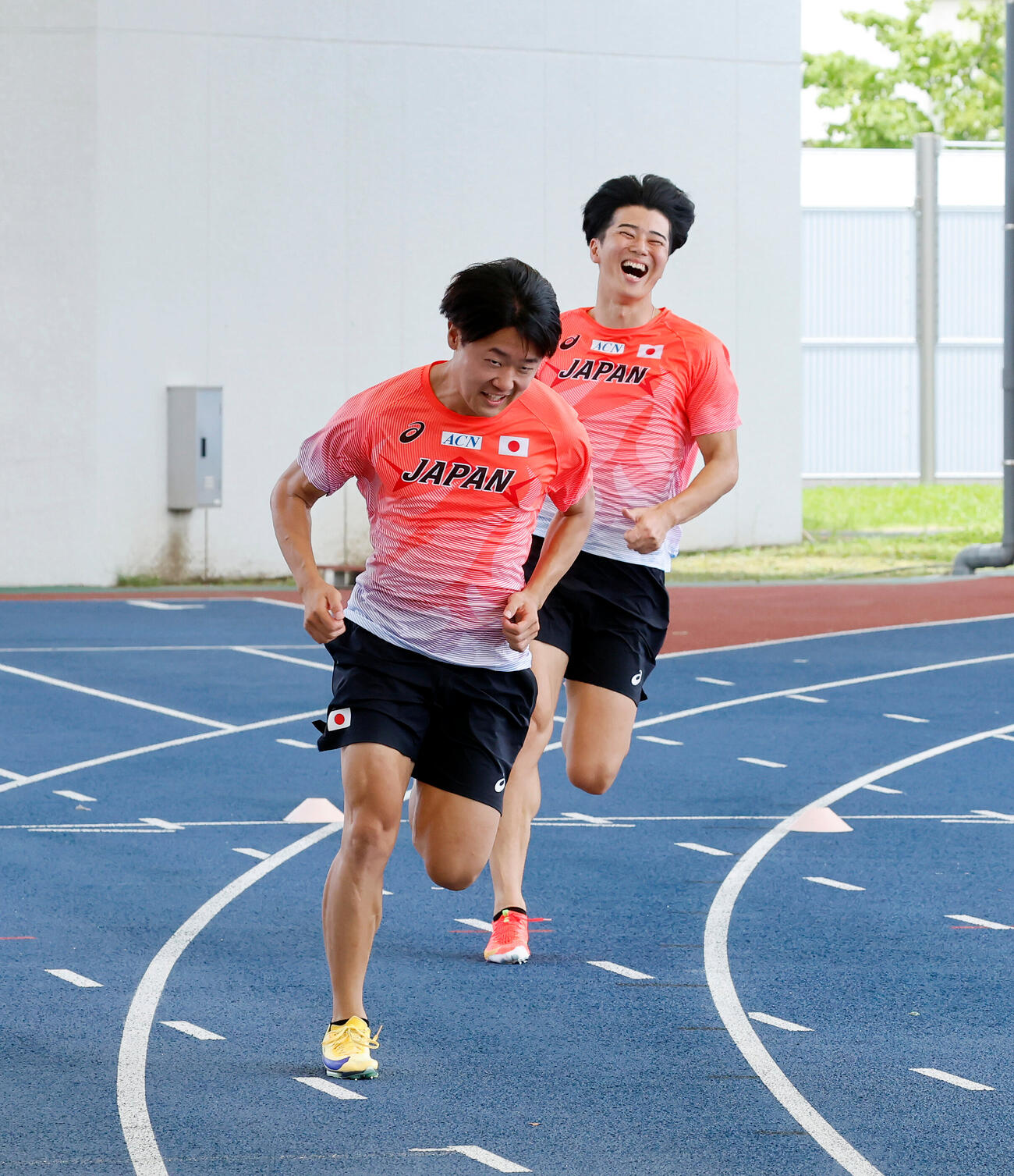バトンパスの練習でタイミングが合わず、笑みがこぼれる小室歩久斗（左）と多田修平（撮影・山本朝陽）