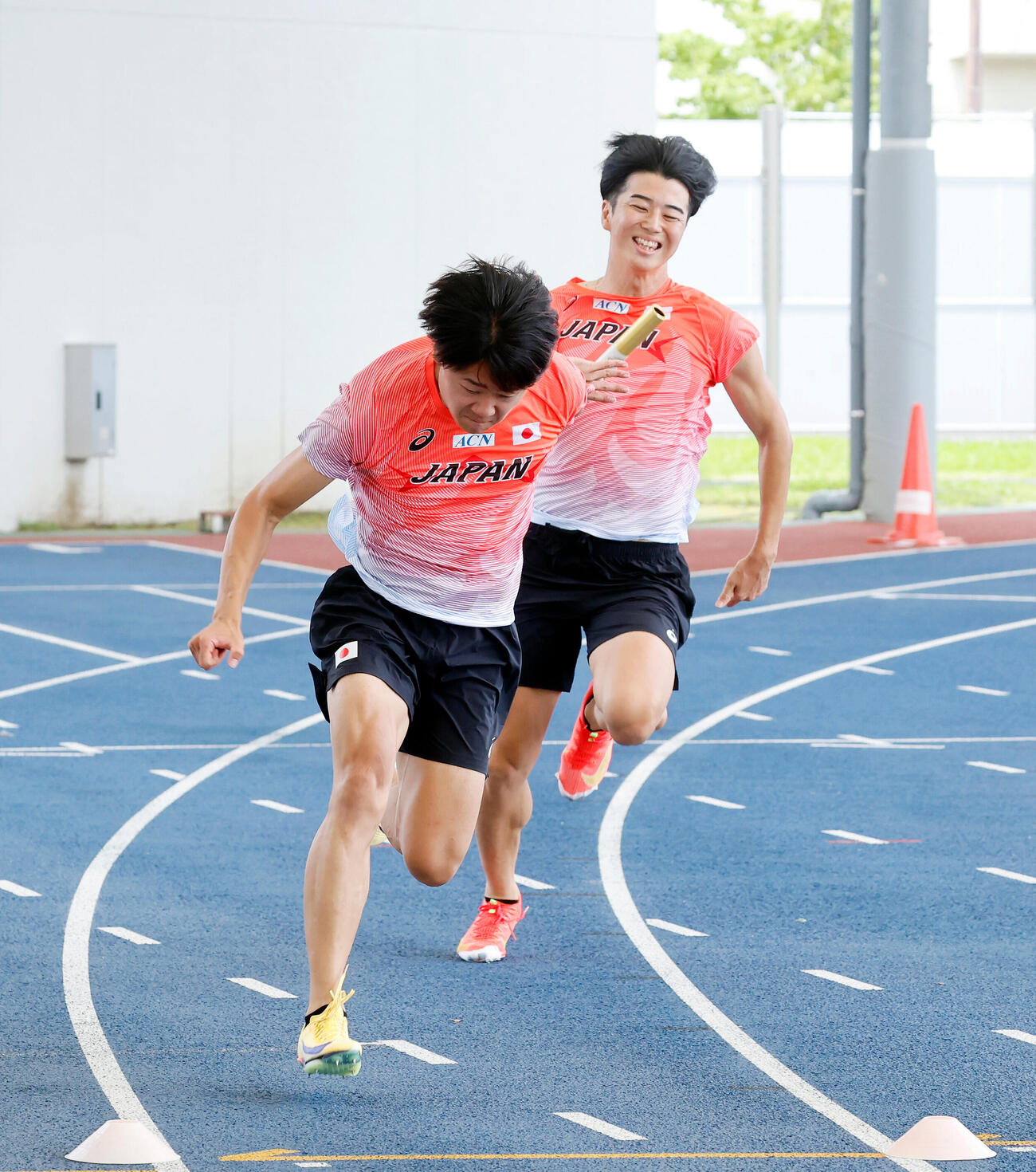 バトンパスの練習でタイミングが合わず、笑みがこぼれる小室歩久斗と多田修平（奥）（撮影・山本朝陽）