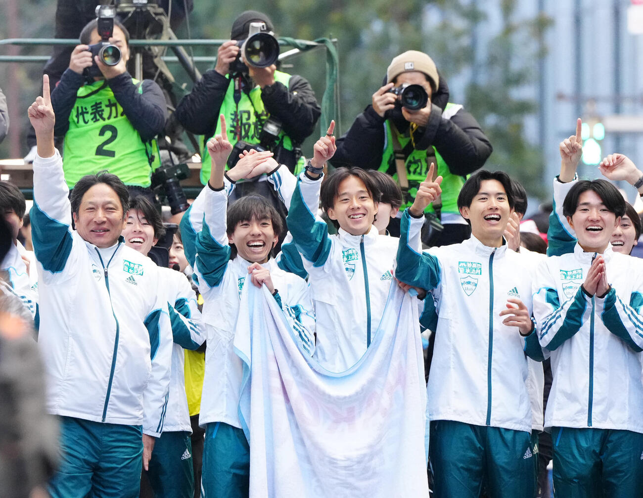 箱根駅伝総合優勝のゴールに向かう10区折田を待ち構える青学大の選手たち。左から原監督、黒田、塩出、佐藤愛、石川＝2026年1月3日