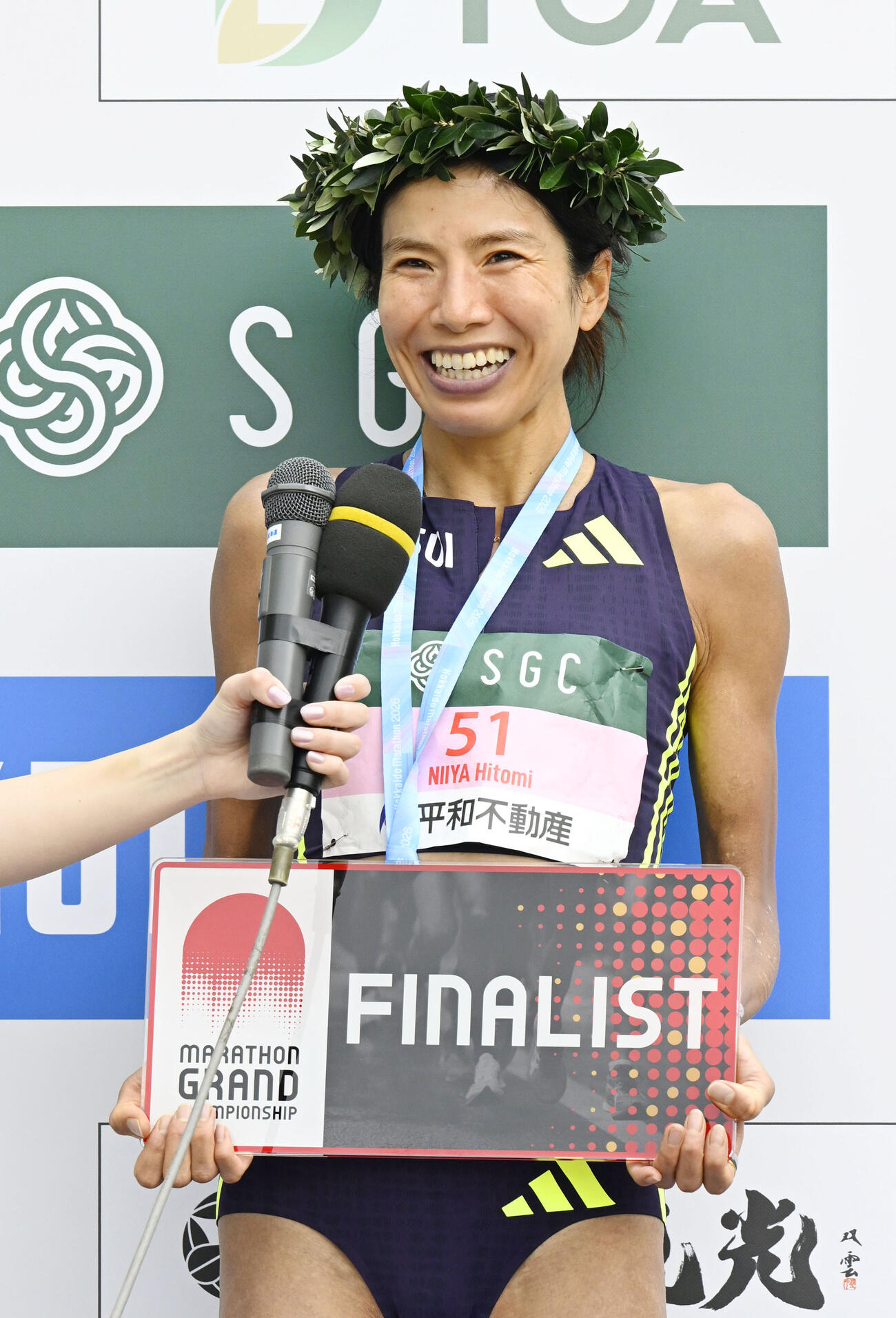 女子を2時間24分14秒で制し、レース後に笑顔を見せる新谷仁美（共同）