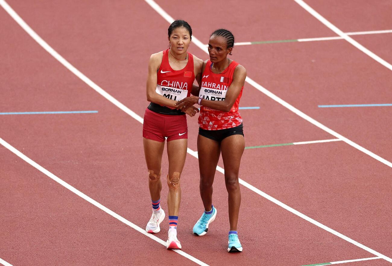 アジア大会女子マラソンで金メダルを獲得したハブテ（右）は銀の中国・次仁措姆とたたえ合う（ロイター）