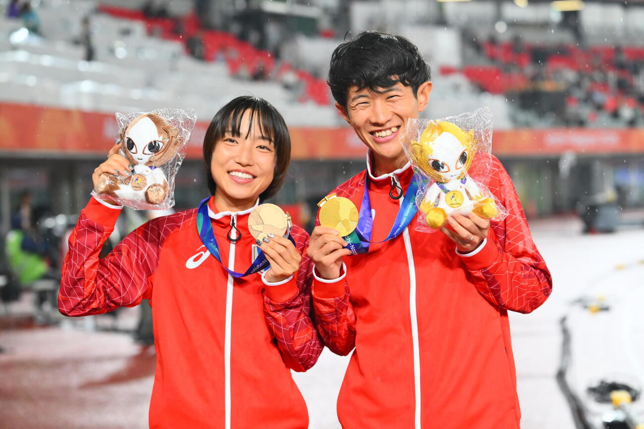 男子マラソン金メダルの山下一貴（右）と女子マラソン銅メダルの矢田みくには笑顔で記念撮影（撮影・滝沢徹郎）