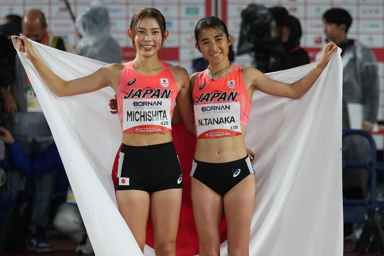 女子1500メートル　日の丸を掲げる田中希実（右）と道下美槻（AP）