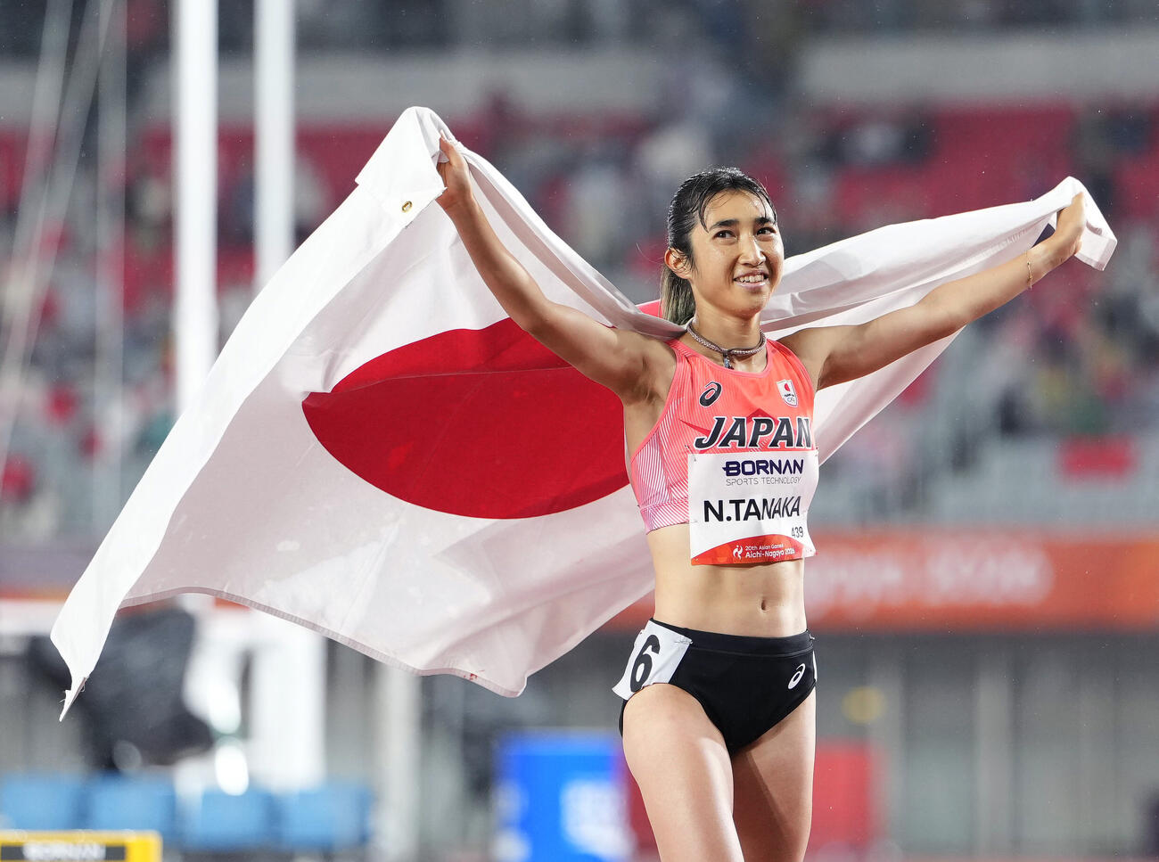 女子1500メートルで3位となり日の丸を掲げる田中希実（共同）