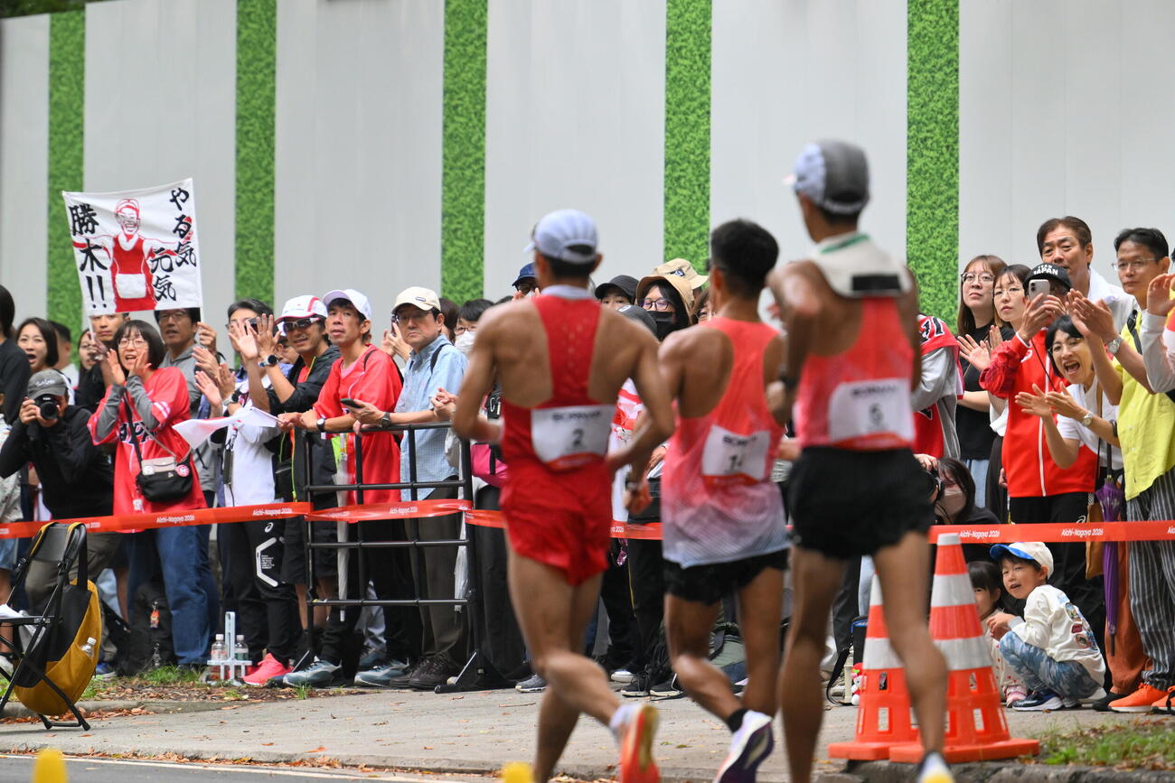 男子マラソン競歩で歩く勝木隼人（手前中央）の応援団（撮影・滝沢徹郎）