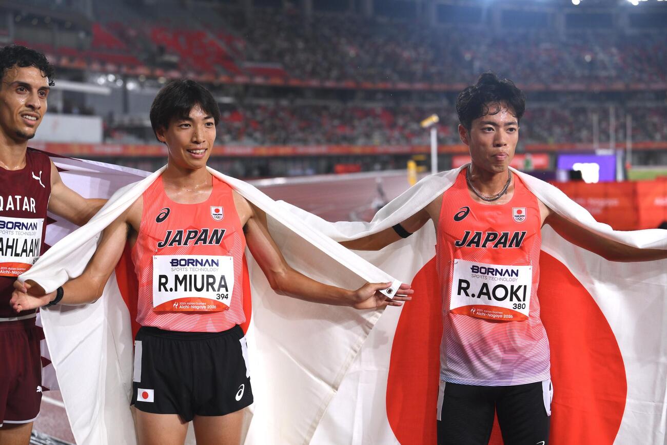 男子3000メートル障害決勝で優勝の三浦龍司（中央）は3位の青木涼真（右）と日の丸を背に記念撮影する（撮影・滝沢徹郎）