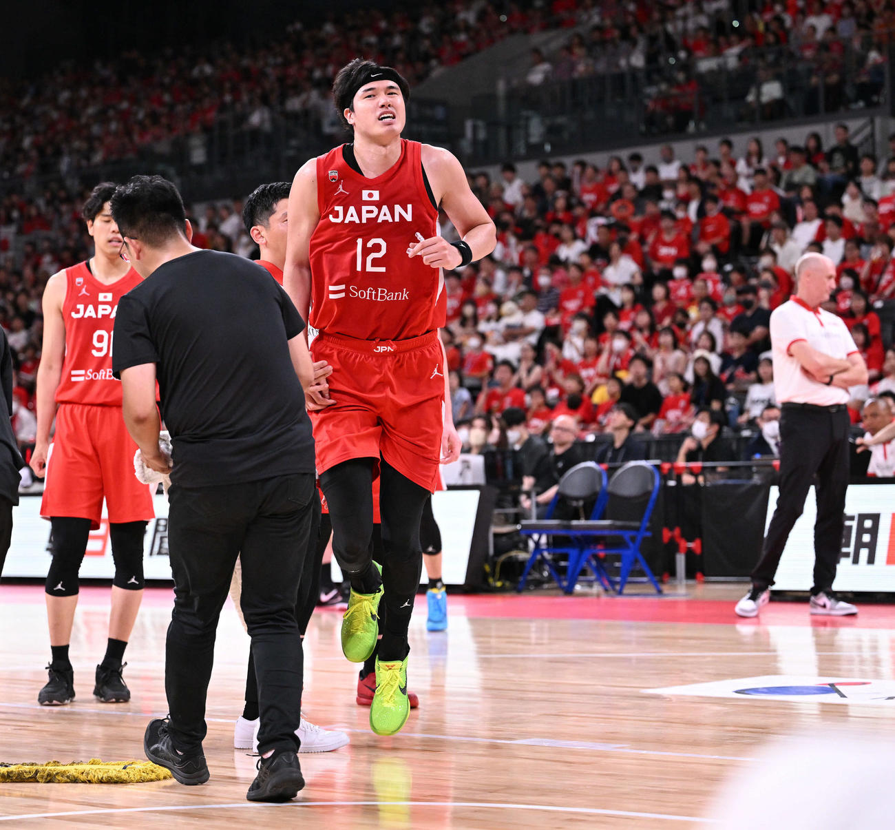15日、アンゴラ戦の第2Q、アクシデントに苦痛の表情でコートを出る渡辺（手前）。後方右はホーバス監督