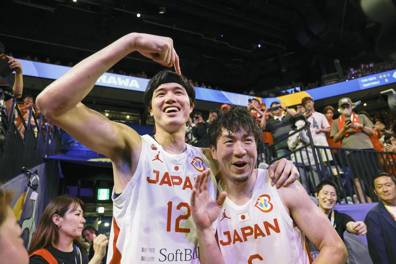 ベネズエラ戦の勝利の立役者となった比江島（右）をたたえる渡辺（共同）