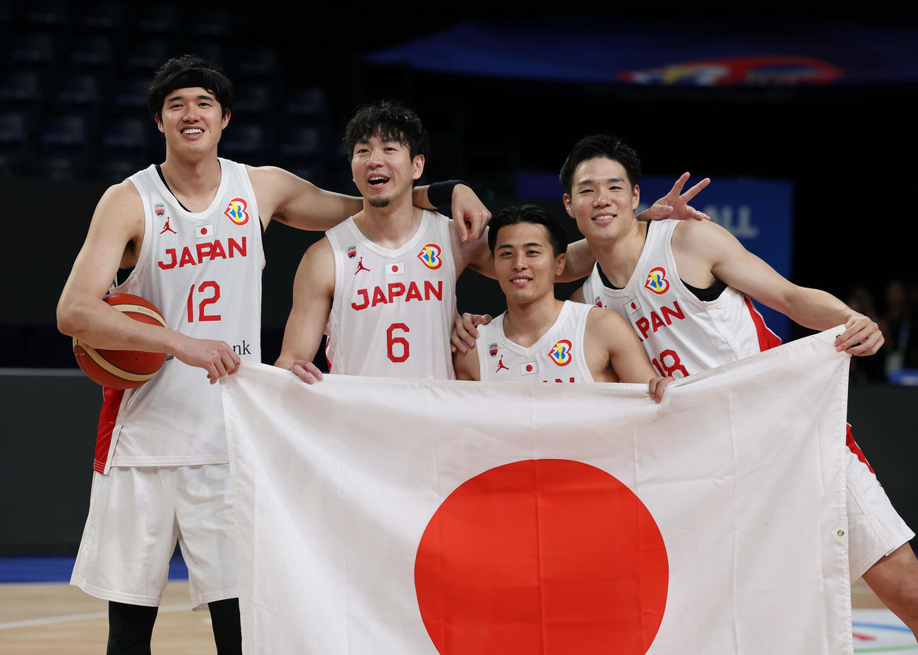 日本対カーボベルデ　パリ五輪出場を決め日の丸を手に笑顔で記念撮影する、左から渡辺、比江島、富樫、馬場（撮影・前田充）