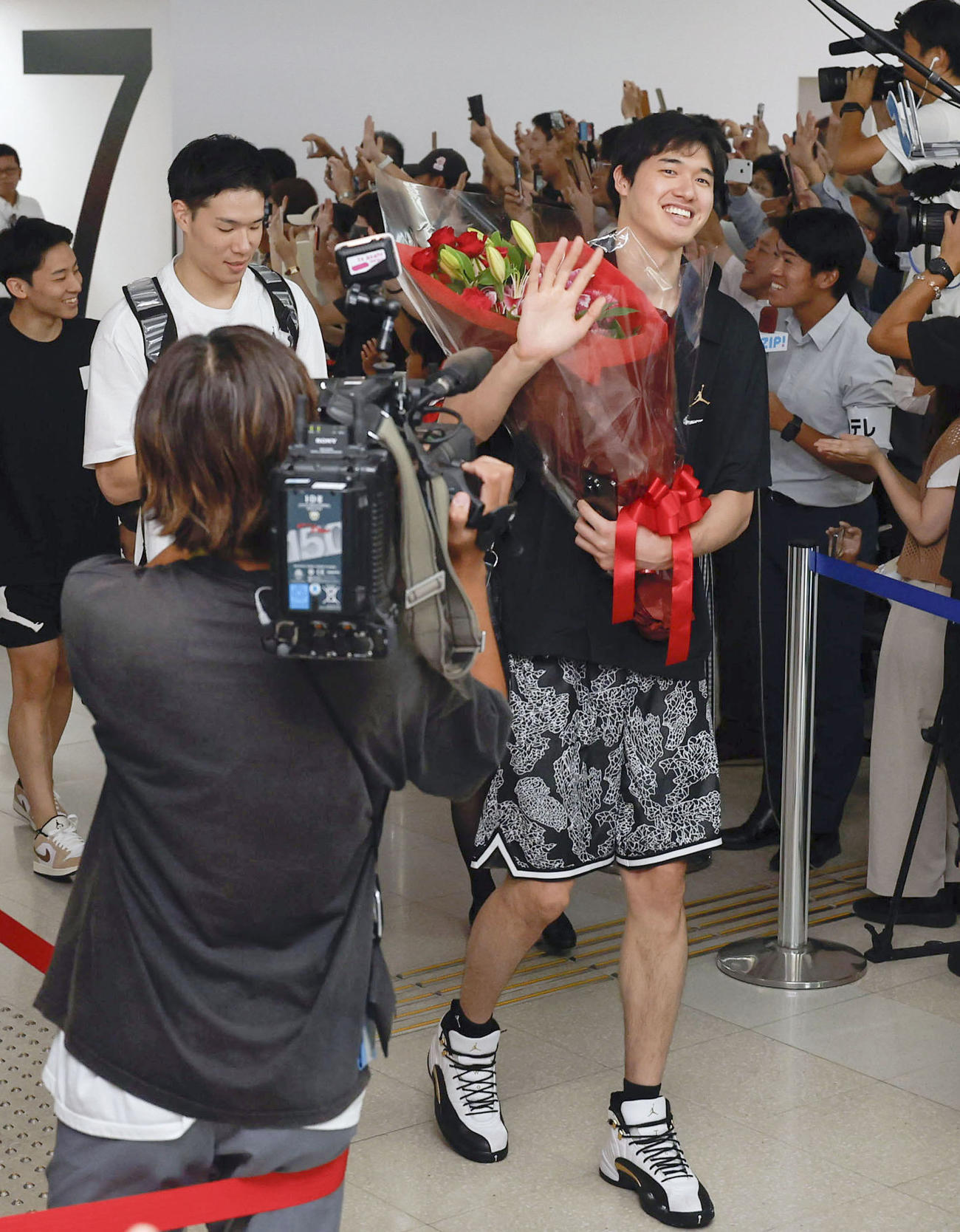 羽田空港に到着し、笑顔で手を振るバスケットボール男子日本代表の渡辺雄太（右）ら（共同）